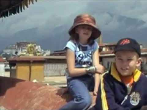 
Young son and daughter on Jokhang roof with Potala Palace behind - Tibet An Adventure With Our Children Youtube Video by Ed van der Kooy and Piet Warffemius

